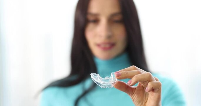 Woman is holding plastic mouth guard. Orthodontic and dental treatment concept