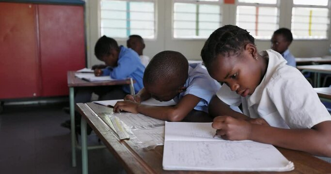 Close-up. Black African school children drawing at a desk in a classroom in Africa  - Powered by Adobe