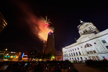 Fototapeta na wymiar Downtown Fort Wayne courthouse lawn with crowd watching 4th of July fireworks over Lincoln Tower