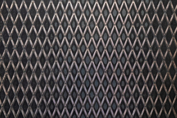 Fragment of the flooring made of black corrugated metal sheet. The pattern has the shape of a grid...