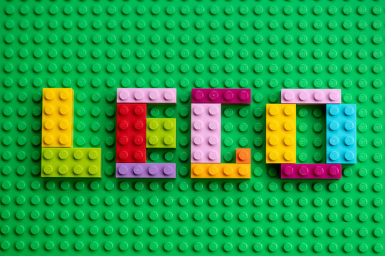 Smolensk - September 21, 2023: Colorful mosaic letters with Lego text made from Lego bricks on a green base plate background.
