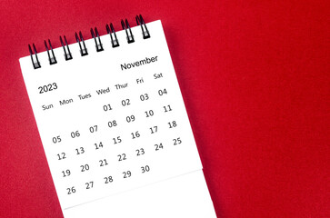 The November 2023 Monthly desk calendar for 2023 year on red background.