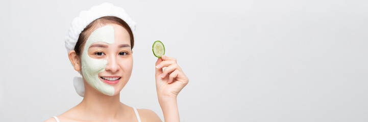 Beautiful girl holding a slice of cucumber in front of her face. - 650670762