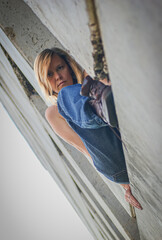 Young woman in rough clothes posing in an abandoned house