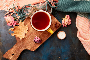 Autumn-Inspired hot beverage among dry roses and leaves.