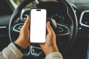 A phone with an isolated screen in the hands of a woman in a car