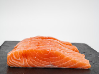 Salmon fish fillet on Slate stone. Red fish fillet close-up on a white background.