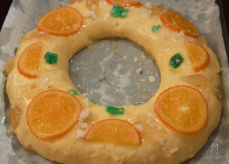 Raw roscon de reyes that is decorated with candied fruits