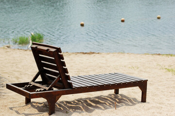 Wooden sun loungers on beach at resort.