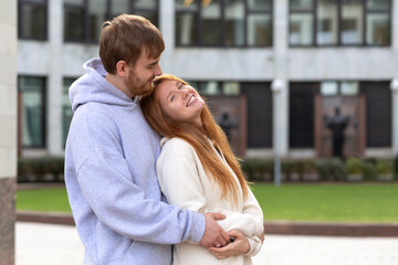 husband, wife, family, couple in love hugging, embracing. girl, guy spend time together outdoors. young woman, man beginning loving romantic relationship. happy male, female smiling
