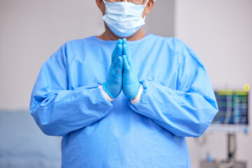 Fototapeta premium Doctor, praying and hands with healthcare and surgery, seek guidance from God and worship, hope and operation room. Surgeon person in theatre, prayer and respect with plea, health and ask for help