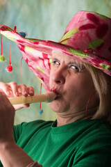 Clown in a hat. The buffoon grimaces and entertains. Portrait of a dressed up artist.