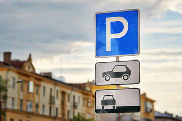 Road sign - Parking sign in the city. Parking zone for cars. Parking sign, city on background
