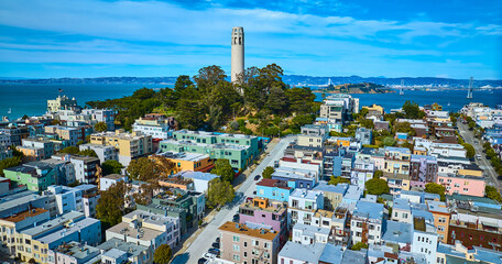 Aerial houses leading up to Telegraph Hill with Coit Tower and bay and bridge behind it