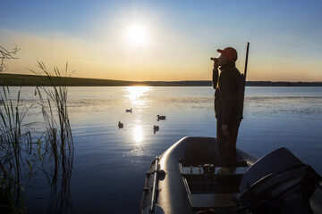 Hunter calling ducks at lake. duck hunter.