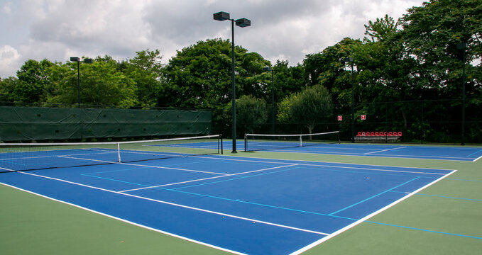 Cross court view of pickleball tennis courts painted blue and green
