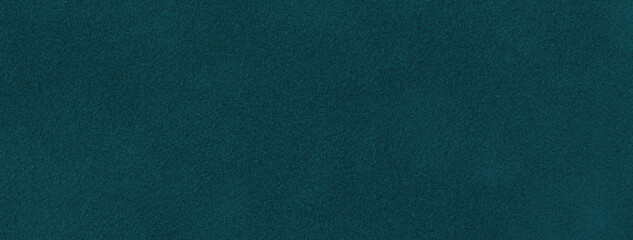 Texture of dark green and emerald velvet matte background, macro. Suede teal fabric with pattern.