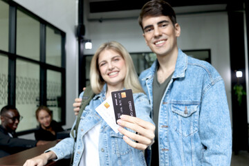 Beautiful woman traveler with long blonde hair showing credit card to camera went checking in at...