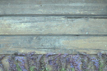 Lavender and sage flowers on a wooden table close-up. Horizontal planks of dark old wood with...