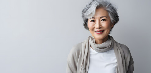 Asian elderly woman in  white blouse isolated on light grey background - obrazy, fototapety, plakaty