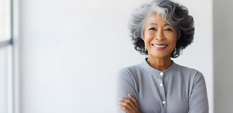Asian elderly woman in  white blouse isolated on light grey background