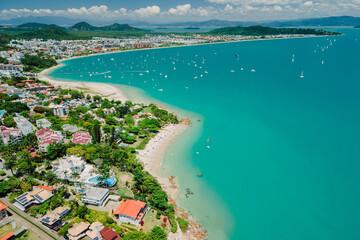 Tropical holiday beach with resort village and quiet ocean in Brazil. Aerial view