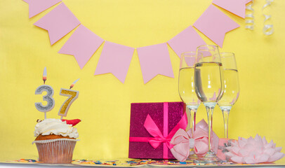 Date of birth with number 37. Festive pudding pie with a candle. Happy birthday decorations for a...