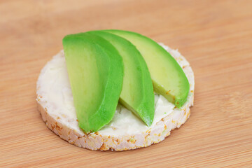 Rice Cake Sandwich with Fresh Avocado and Cream Cheese on Bamboo Cutting Board. Easy Breakfast....