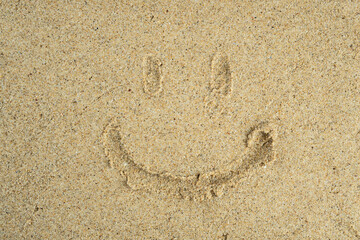Fototapeta na wymiar smile symbol drawn on the sand