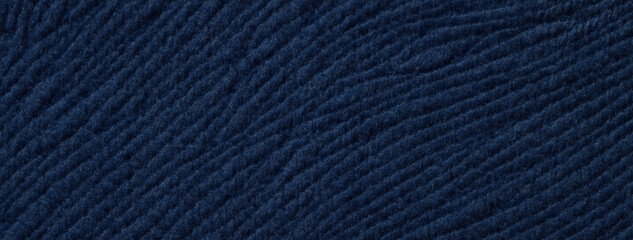 Texture of woolen navy blue textile background from a soft wool material, macro. Fabric with wavy...