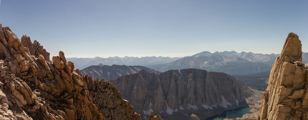 Panorama view of many tops and peaks of mountains in Sierra Nevada with lake in America