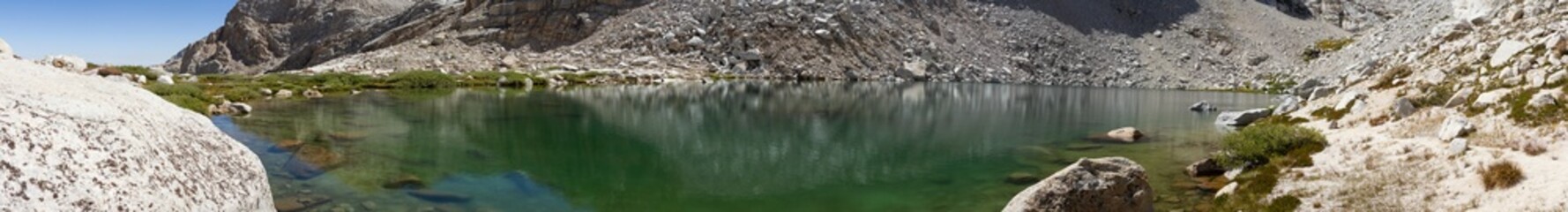 Fototapeta na wymiar Panorama shot of clear water in Scout Boys lake with white granite rockc around at sunny day, usa