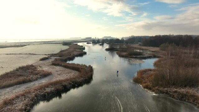 Ice skating on the Drontermeer lake in nature seen from above during a cold winter day in The Netherlands.