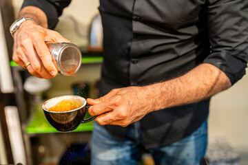 crop of the hands of a professional barista preparing a coffee in a cup inside a specialty coffee