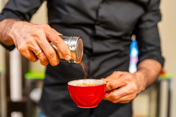 crop of the hands of a professional barista preparing a coffee in a cup inside a specialty coffee