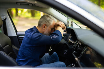 Mid age man sitting inside car is very upset and stressed - Powered by Adobe