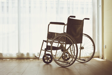 Fototapeta na wymiar empty wheelchair at home vintage tone for grief sadness pass away loss beloved elder people