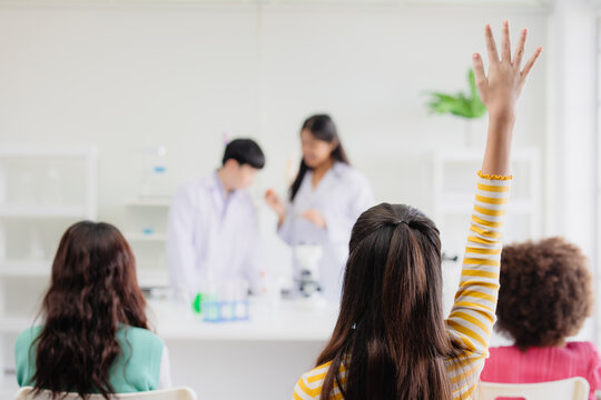 Smart student rising hand have a question to scientist role play in science modern school class room