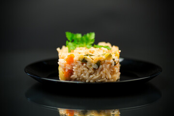 Cooked boiled rice with zucchini, carrots and vegetables in a plate