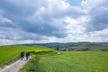 pellegrini in cammino colline verdi con via francigena in toscana