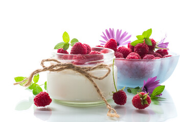 Sweet cooked homemade yogurt with fresh raspberries in a glass jar.