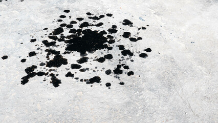 Abstract black engine oil drop on concrete floor texture backgruond.
Automobile garage dirty old oil stain cement pattern.  