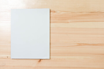 Mockup of blank book cover white on textured wooden background. 
Empty magazine template to your design. 
top view.  