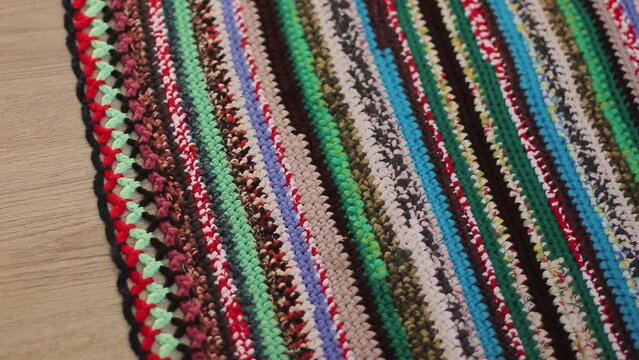 Knitted background, knitted fabric, knitted texture. Soft material. Handmade carpet closeup photo. Cozy background. Knitted details.