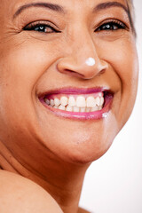 Fototapeta premium Face, cream and beauty of a mature woman with glow and smile on a white background. Dermatology, moisturizer and cosmetics zoom of aesthetic model for facial shine, portrait and skincare in studio