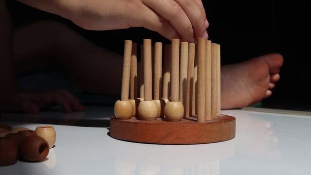 logic wooden board game and a boy playing with it close-up