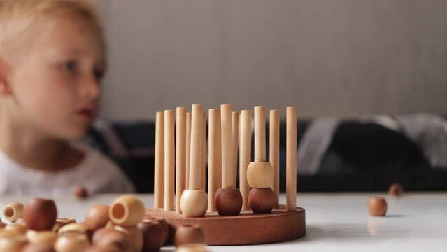 logic wooden board game and a boy playing with it close-up