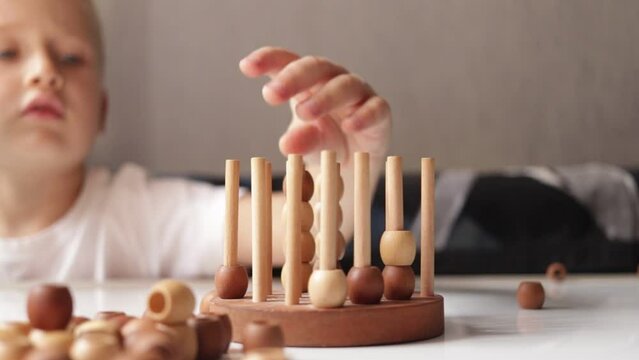 logic wooden board game and a boy playing with it close-up