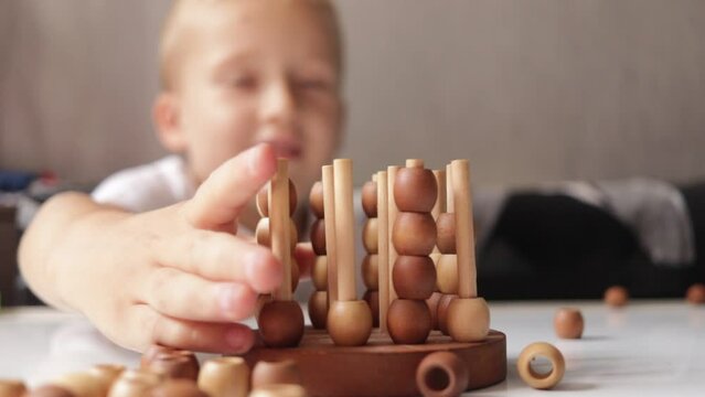 logic wooden board game and a boy playing with it close-up