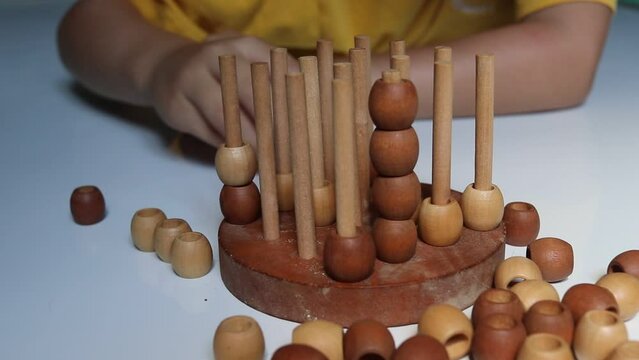 logic wooden board game and a boy playing with it close-up